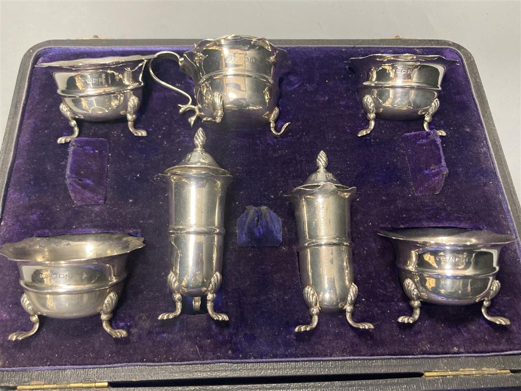 An Edwardian cased seven piece silver condiment set, Birmingham, 1907, (lacking spoons).